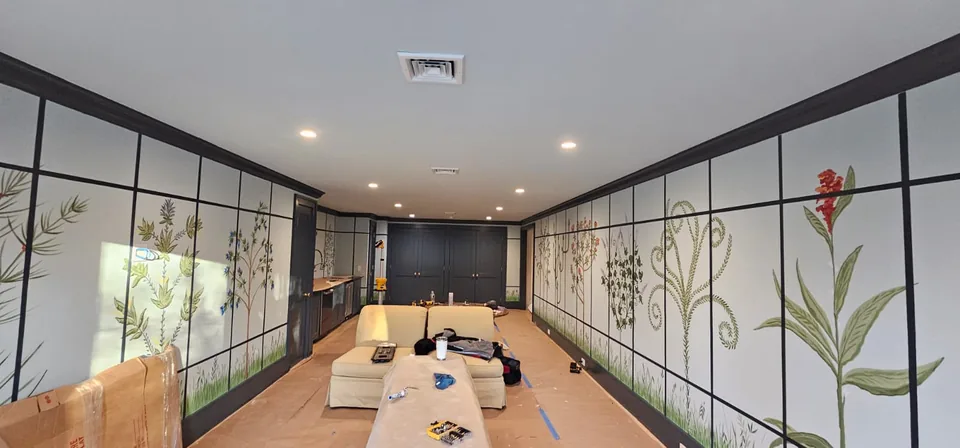 Interior room with decorative walls and protected floors during painting work