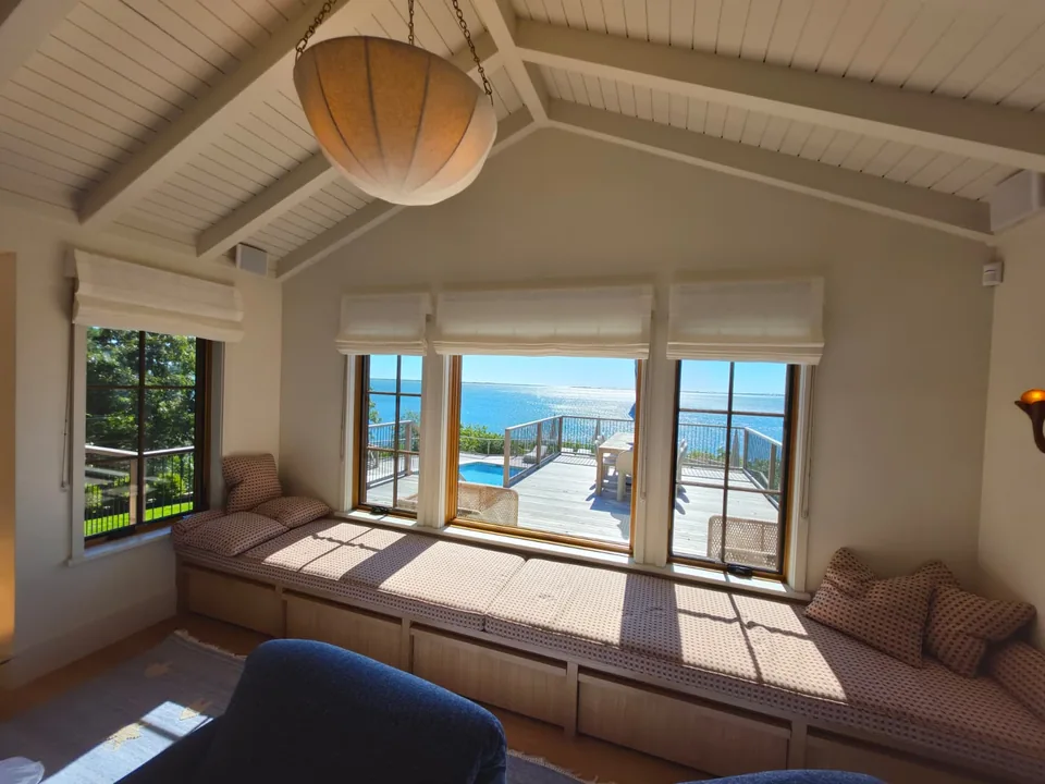 White Roman shades installed above seaside windows