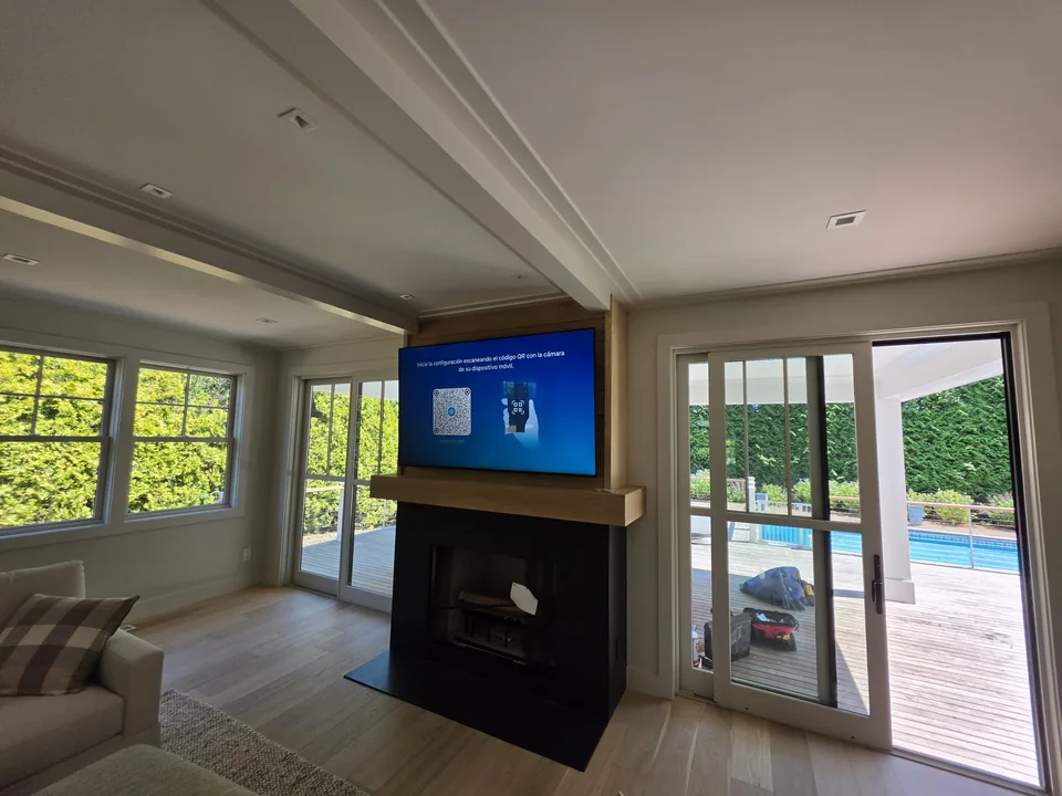 Television installed above a living room fireplace
